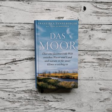 Auf dem Bild ist das Buch "Das Moor" von Franziska Tanneberger und Vera Schroeder auf einer hellen, holzähnlichen Fläche abgebildet. Es dient als Headerbild für den Blogbeitrag.