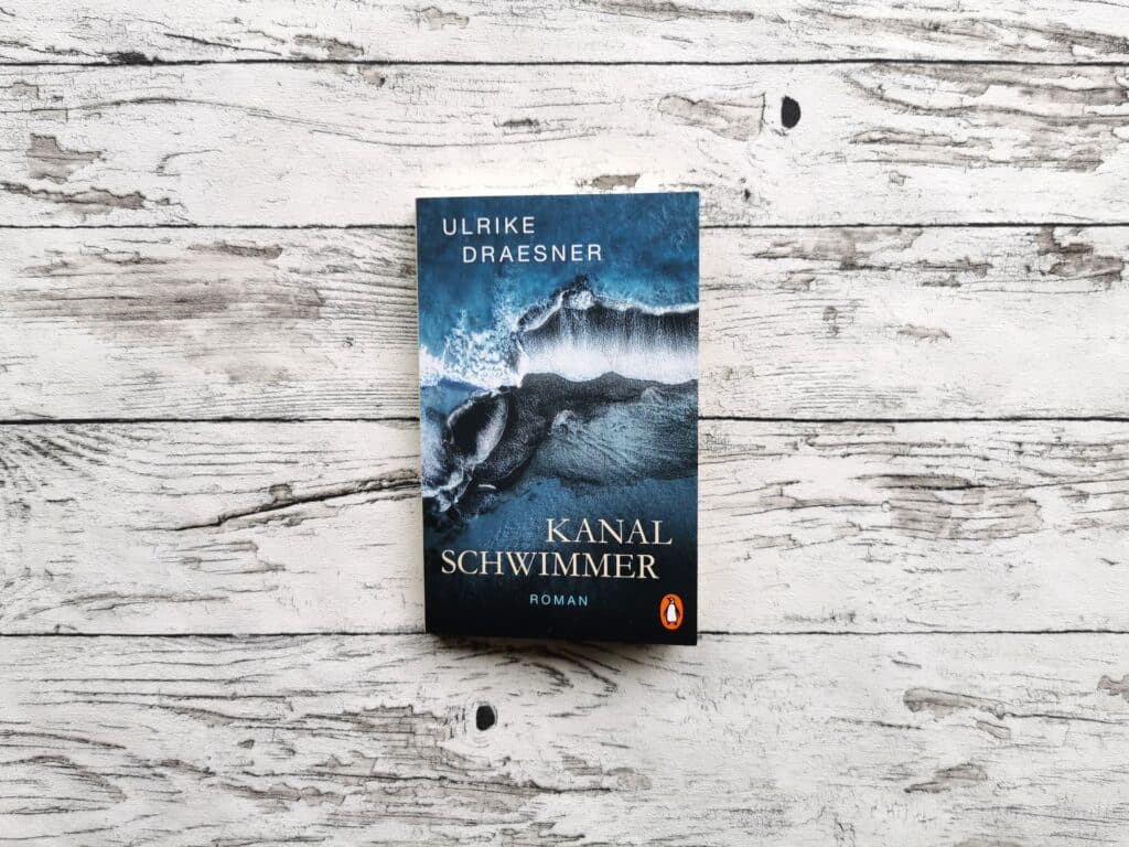 Auf dem Bild ist das Buch "Kanalschwimmer" von Ulrike Draesner auf einer hellen, holzähnlichen Oberfläche.
