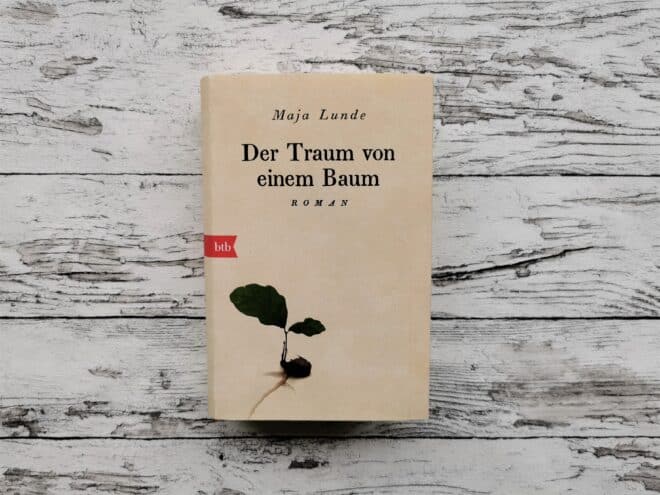 Auf dem Bild ist das Buch "Der Traum von einem Baum" von Maja Lunde auf einer hellen, holzähnlichen Fläche abgebildet. Es ist das Headerbild der Rezension des Buches.