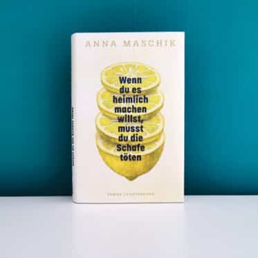 Auf dem Foto ist das Buch Wenn du es heimlich machen willst, musst du die Schafe töten von Anna Maschik auf einer weißen Oberfläche vor einer grünen Wand stehend abgebildet. Es ist das Header-Bild zur Rezension des Buches.