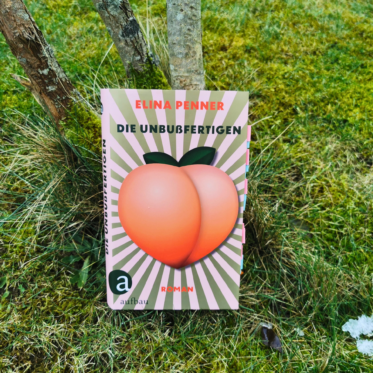 Auf dem Foto ist das Buch Die Unbußfertigen von Elina Penner an einen Baum gelehnt auf einer grünen Wiese fotografiert. Es dient als Header-Bild für eine Rezension des Buchs.