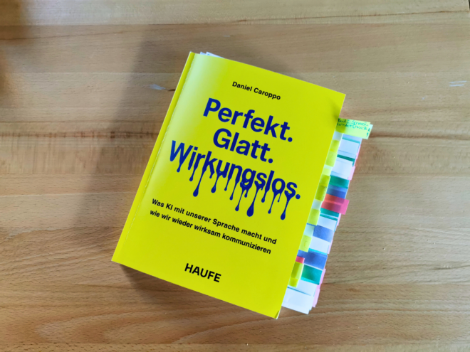 Auf dem Foto ist das Buch Perfekt. Glatt. Wirkungslos. von Daniel Caroppo auf einem Holztisch liegend fotografiert. Es ist das Header-Bild der Rezension des Buchs.