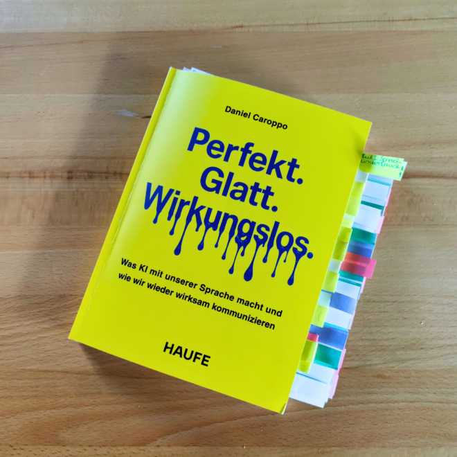 Auf dem Foto ist das Buch Perfekt. Glatt. Wirkungslos. von Daniel Caroppo auf einem Holztisch liegend fotografiert. Es ist das Header-Bild der Rezension des Buchs.