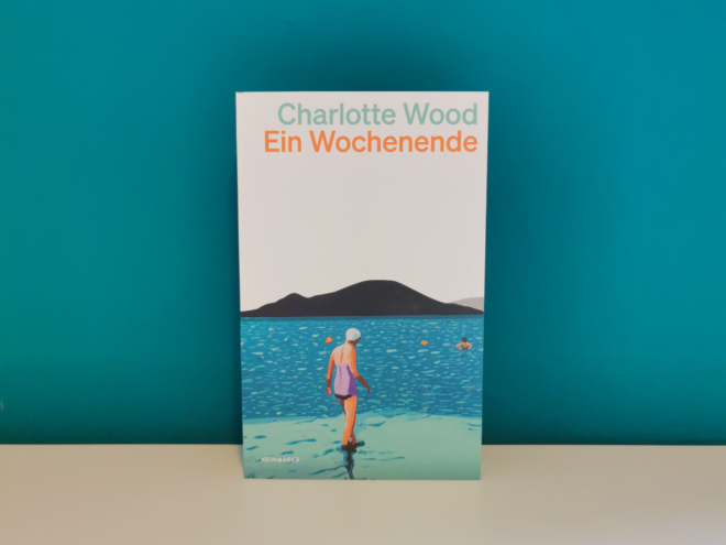 Auf dem Foto ist das Buch "Ein Wochenende" von Charlotte Wood vor einer dunkelgrünen Wand stehend fotografiert. Es ist das Header-Bild zu meiner Rezension des Buchs.